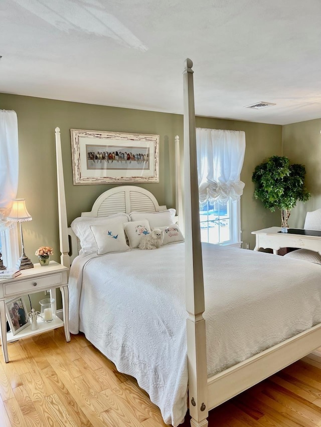 bedroom with visible vents and wood finished floors