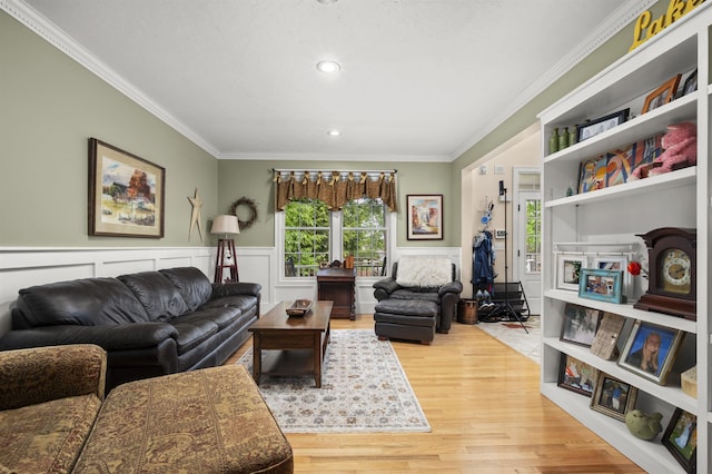 living area with ornamental molding, wainscoting, and wood finished floors