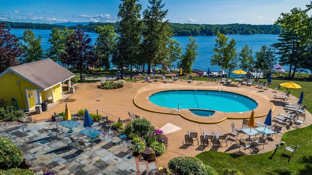 view of pool with a water view, a patio, and an in ground hot tub