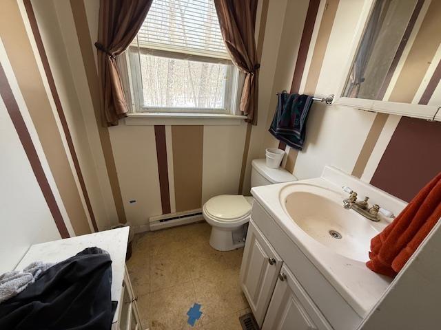 bathroom with a baseboard heating unit, vanity, and toilet