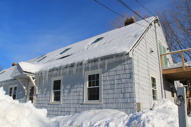 snow covered property featuring a chimney