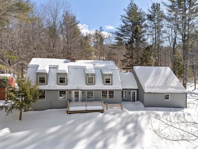 snow covered property with a deck