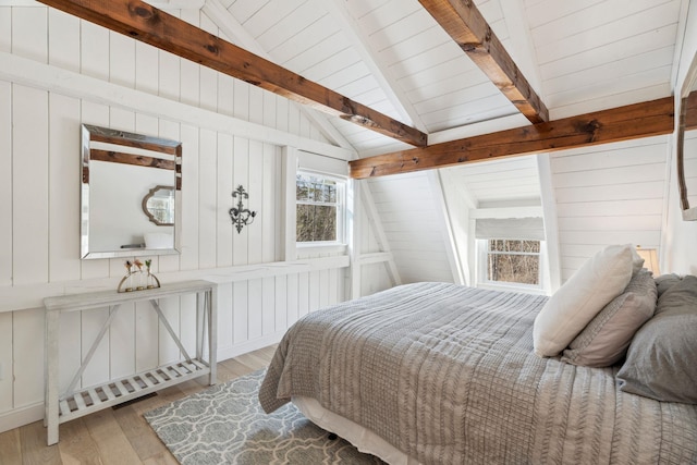 bedroom with wood ceiling, vaulted ceiling with beams, wood walls, and wood finished floors