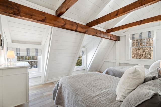 bedroom with light wood-style flooring, multiple windows, lofted ceiling with beams, and wooden walls