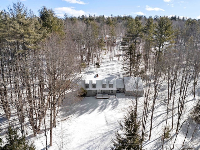 snowy aerial view featuring a forest view