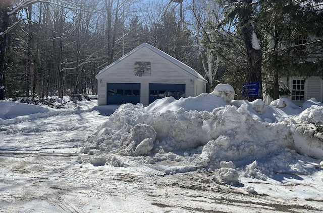 snow covered garage with a detached garage