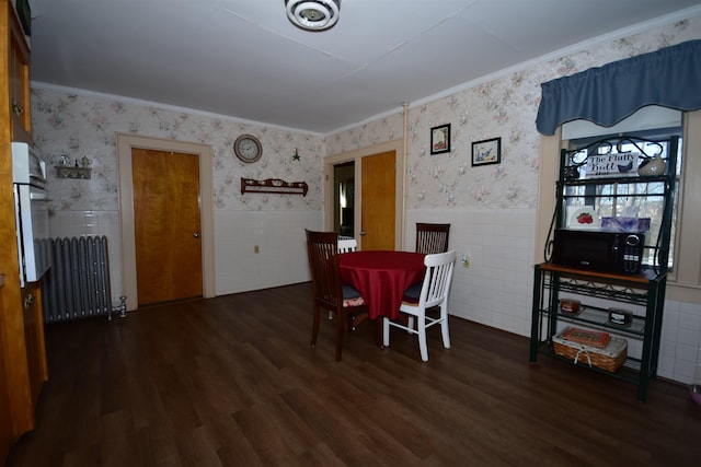 dining area with wood finished floors, a wainscoted wall, radiator heating unit, and wallpapered walls