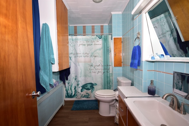 full bathroom with toilet, radiator heating unit, wood finished floors, shower / bath combination with curtain, and tile walls