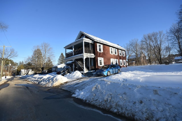 snow covered property with a balcony