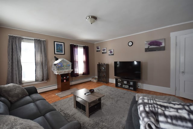 living room featuring a baseboard heating unit, wood finished floors, a wealth of natural light, and baseboards