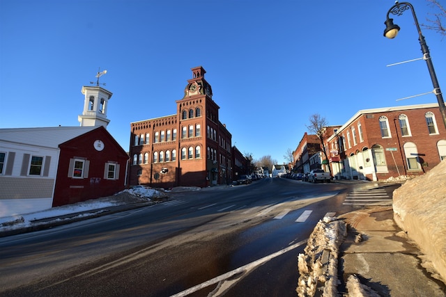 view of road featuring curbs, street lighting, and sidewalks