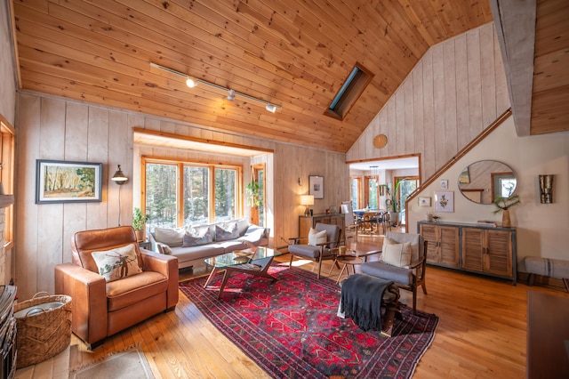 living room with a skylight, wood ceiling, rail lighting, and wood-type flooring