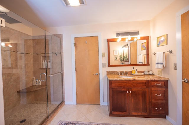 bathroom featuring visible vents, a shower stall, vanity, baseboards, and tile patterned floors