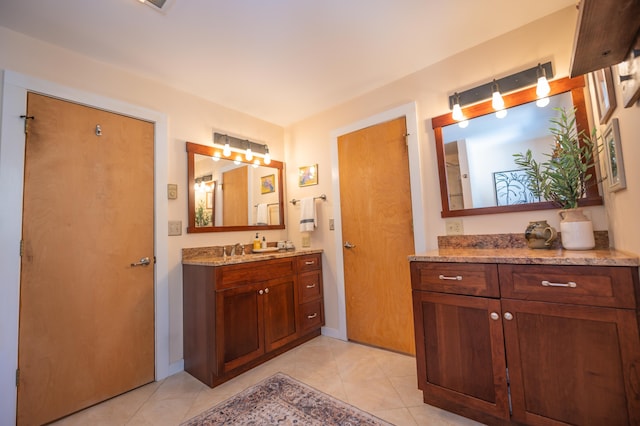 bathroom with baseboards, vanity, and tile patterned floors