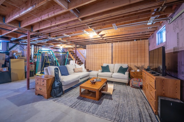 living area with stairway and unfinished concrete flooring