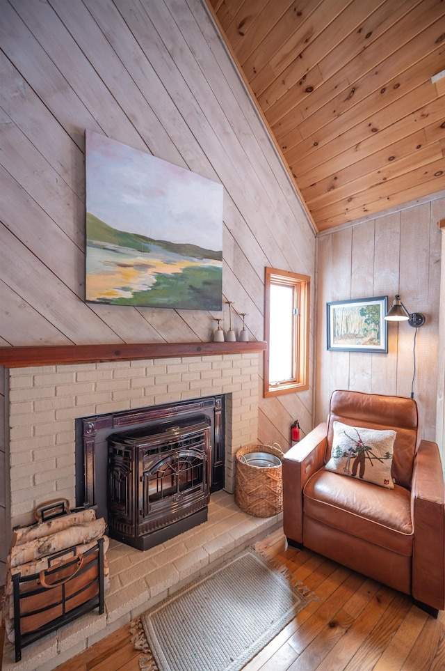 living room with wooden ceiling, hardwood / wood-style floors, a wood stove, vaulted ceiling, and wood walls