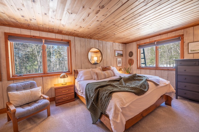 bedroom with wooden ceiling, wood walls, and light colored carpet