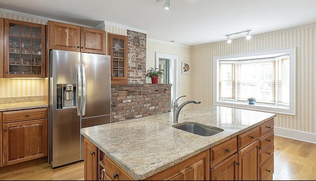 kitchen with brown cabinets, a sink, stainless steel refrigerator with ice dispenser, and light wood finished floors