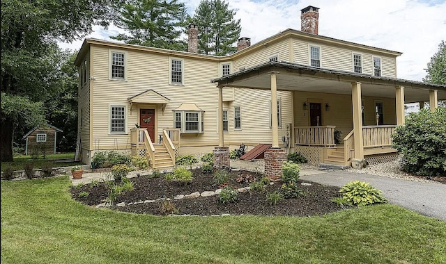 view of front of house with a chimney, a porch, and a front yard