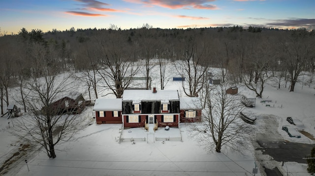 snowy aerial view featuring a forest view