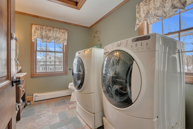 laundry room with a baseboard radiator, baseboards, washing machine and clothes dryer, stone tile flooring, and crown molding