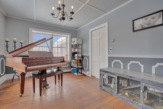 living area with crown molding, a baseboard heating unit, a notable chandelier, and wood finished floors