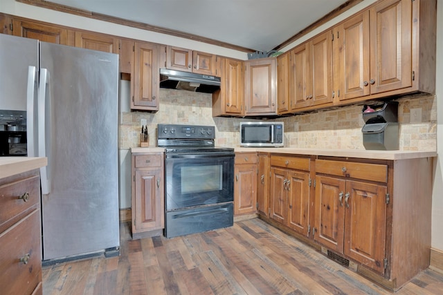 kitchen with light countertops, appliances with stainless steel finishes, and under cabinet range hood