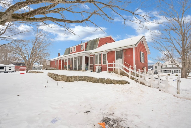 view of front of house with a garage, fence, and a gambrel roof