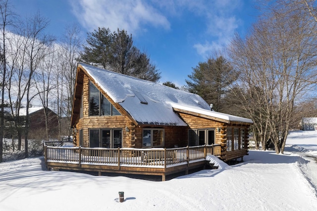 view of front of house with a deck and log exterior