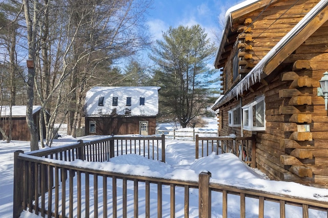 snow covered deck featuring an outbuilding