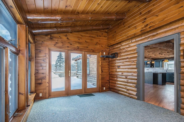 carpeted empty room featuring lofted ceiling with beams, wood ceiling, a sink, and french doors