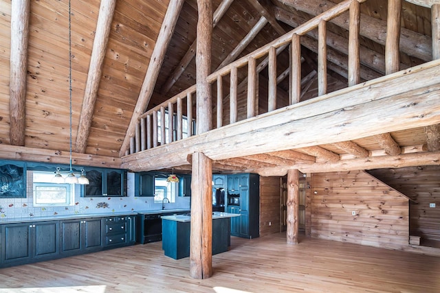 kitchen featuring beam ceiling, light wood-style flooring, wood ceiling, a sink, and blue cabinets