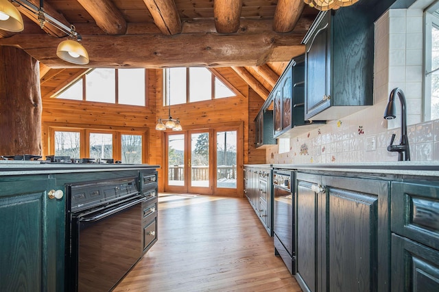 kitchen with gas stovetop, beamed ceiling, light wood finished floors, decorative backsplash, and dishwasher