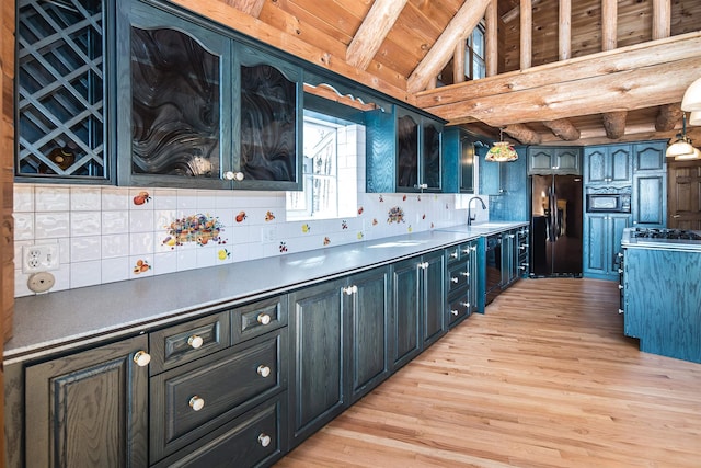 kitchen with tasteful backsplash, lofted ceiling with beams, wood ceiling, light wood-type flooring, and black appliances