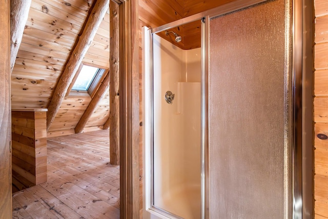 bathroom featuring a skylight, wood ceiling, beamed ceiling, and a shower stall