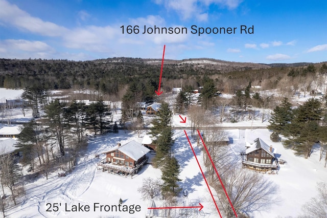 snowy aerial view featuring a forest view