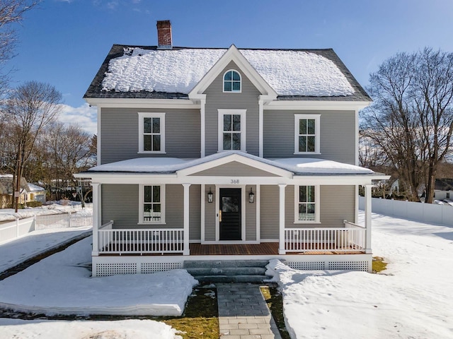 view of front facade with covered porch and a chimney