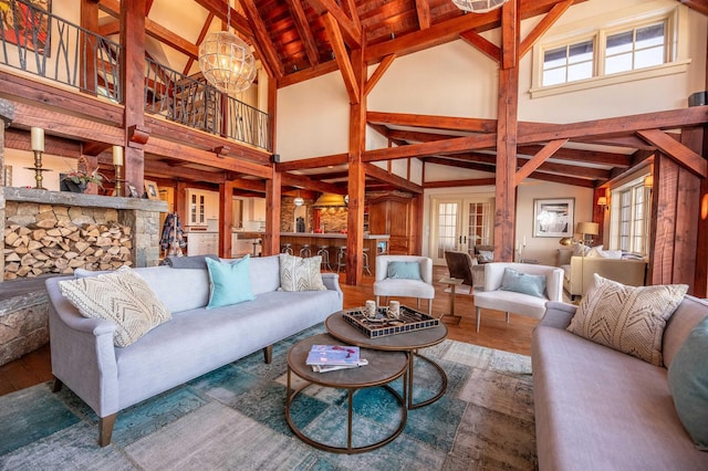 living room with high vaulted ceiling, beamed ceiling, wood finished floors, and an inviting chandelier