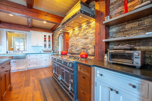 kitchen featuring range with two ovens, extractor fan, light wood-type flooring, white cabinetry, and open shelves