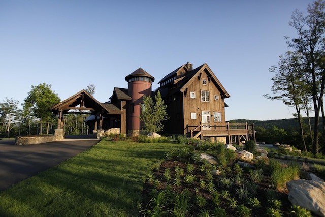 view of front facade featuring a front yard and a wooden deck