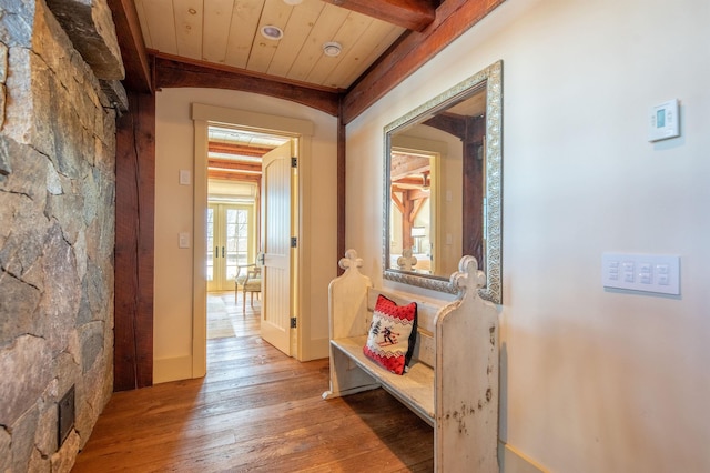 hallway featuring wooden ceiling, beam ceiling, visible vents, and hardwood / wood-style floors