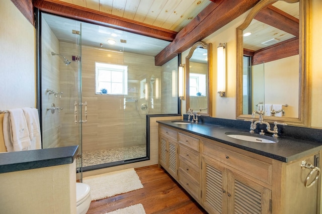 full bathroom featuring a shower stall, a sink, and wood finished floors