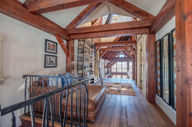 hall featuring lofted ceiling with beams, hardwood / wood-style flooring, and an upstairs landing