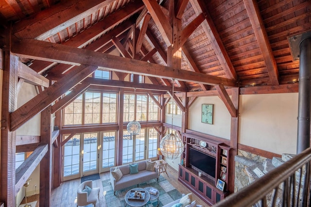 unfurnished living room with high vaulted ceiling, wooden ceiling, wood finished floors, beam ceiling, and a wood stove