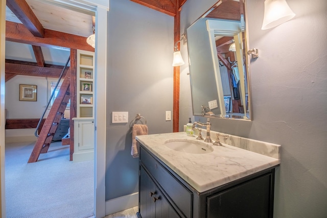 bathroom featuring beamed ceiling and vanity