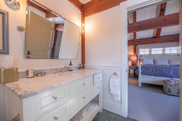 bathroom featuring a wainscoted wall, vanity, and ensuite bath