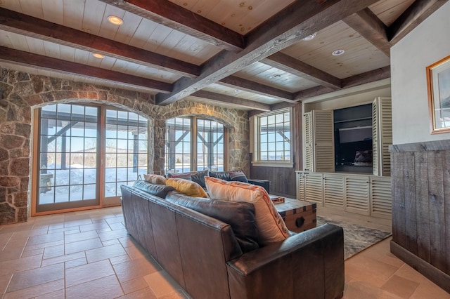 living room with stone tile flooring, wood ceiling, and beamed ceiling