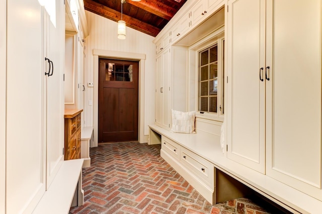 mudroom with vaulted ceiling with beams, brick floor, and wood ceiling