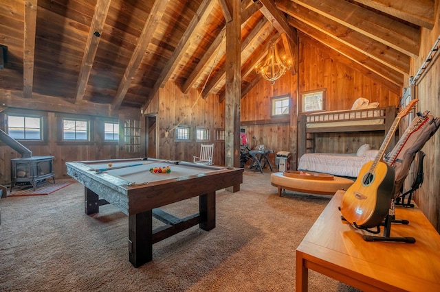 playroom with a wood stove, carpet flooring, vaulted ceiling with beams, and wooden walls