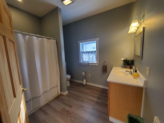 bathroom featuring curtained shower, toilet, wood finished floors, vanity, and baseboards